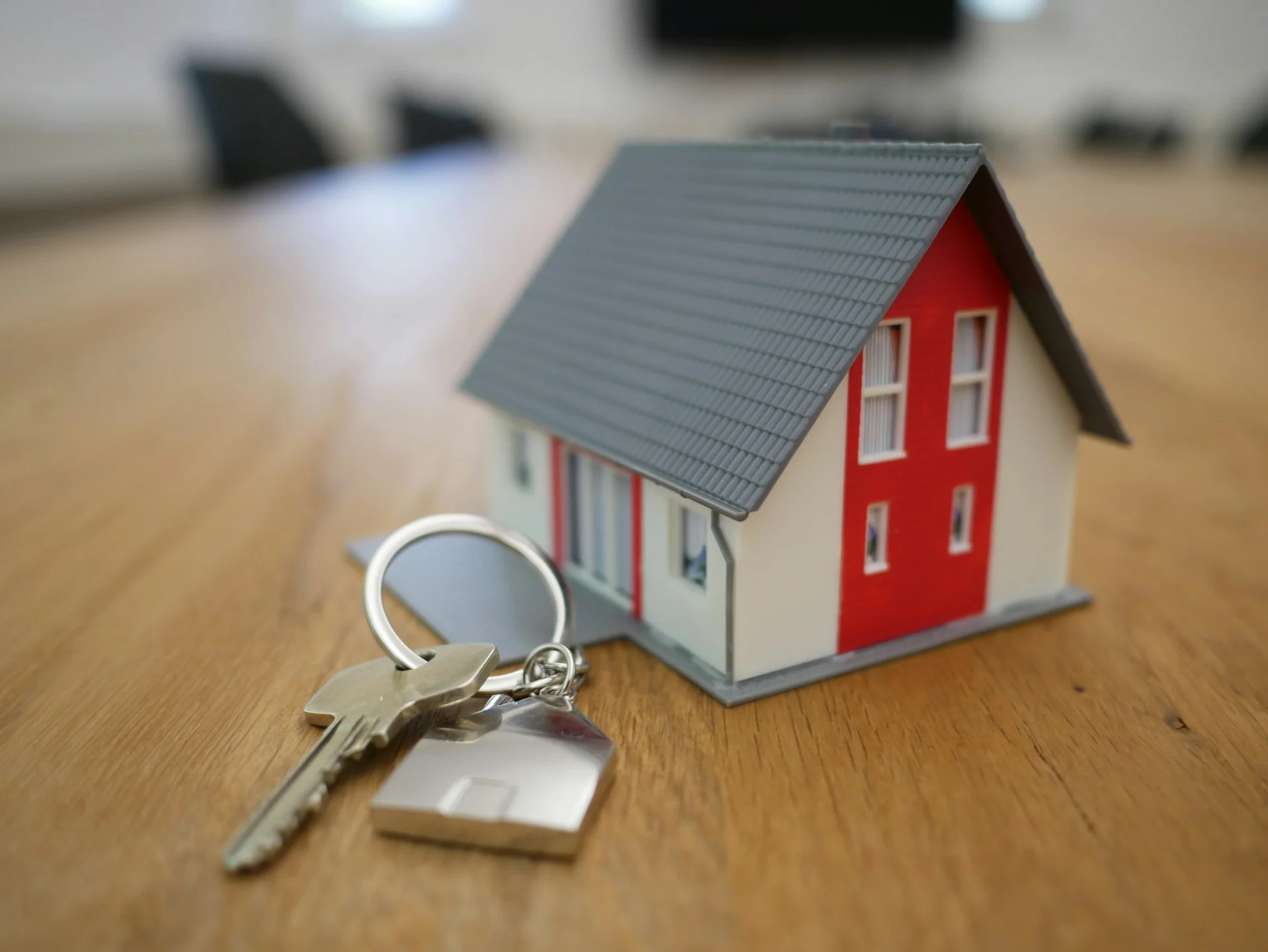 House keys and a model home resting on a table in a new house
